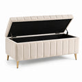 Banc de rangement en velours beige avec pieds en métal doré